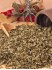 Ein kleiner Haufen gerebelter Liebst�ckel (Maggikraut) mit einer kleine Gew�rzschaufel aus Holz vor einer liegenden Gew�rzm�hle.